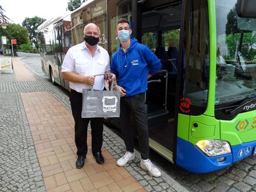 Jason Helm erhielt als 1000. Fahrgast der neuen PlusBus-Linie X2 ein Präsent vom regiobus-Geschäftsführer Hans-Jürgen Hennig (li.)